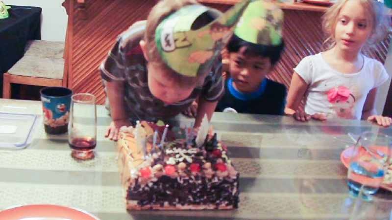 Blowing out candles from on his second cake.